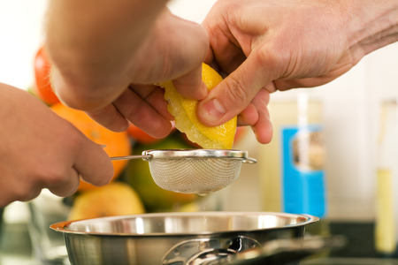 People cooking, squeezing a lemon in order to prepare dessertの写真素材