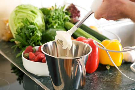 Cook preparing cream using a kitchen mixerの写真素材