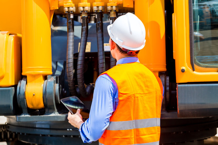 Asian engineer checking plans on construction site