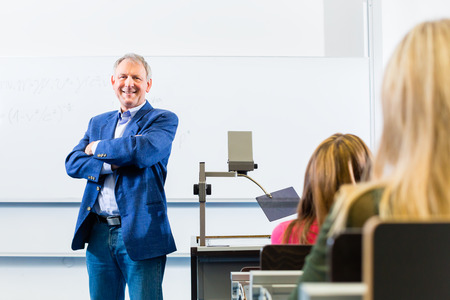 College professor giving lecture in college standing at desk