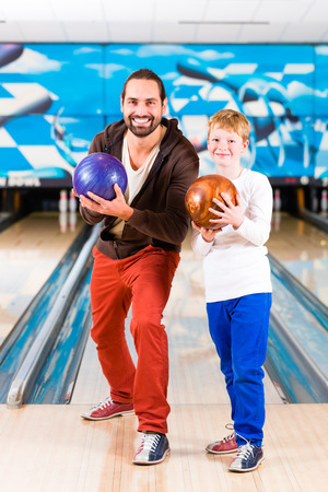 Father and son playing in bowling centerの写真素材