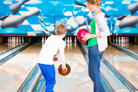 Mother and son playing together at bowling centerの写真素材