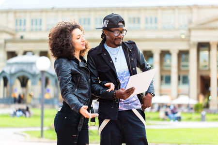 Young African American couple doing sightseeing with city map