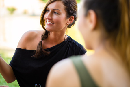 Students in park talk having picnic at riverの写真素材
