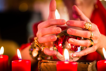 Female Fortuneteller or esoteric Oracle, sees in the future by looking into their crystal ball during a Seance to interpret them and to answer questionsの写真素材