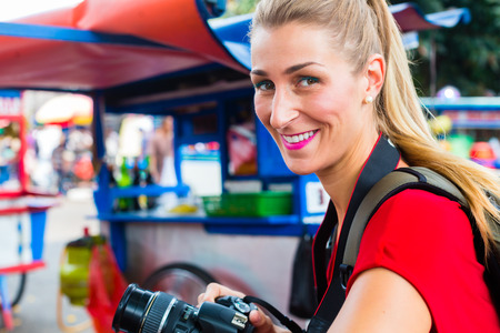 European Woman tourist in Jakarta, Indonesia taking pictures of a street food kitchenの写真素材