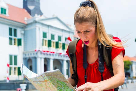 Woman got lost sightseeing with touristic map in Jakarta, Indonesiaのeditorial素材