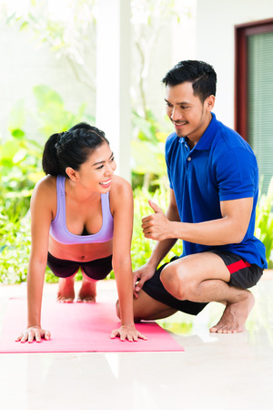 Asian woman and personal trainer at sport exercise doing push-upsの写真素材