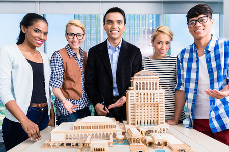 Team of architects presenting model building in presentation to customerの写真素材