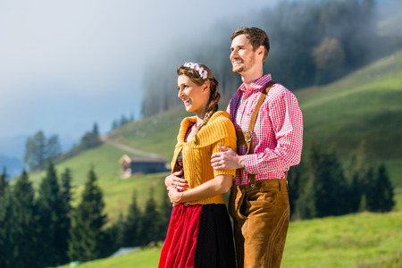 Couple in Tracht on Alp mountain summit at vacationの写真素材