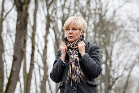 Depressed or sad woman walking down a barren path in winterの写真素材
