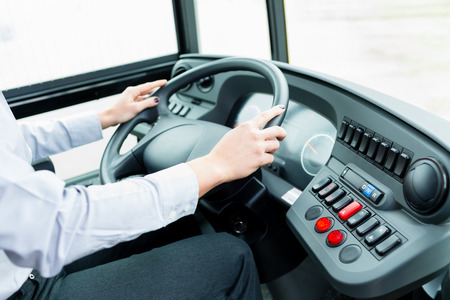Bus driver in cockpit at the wheel drivingの写真素材