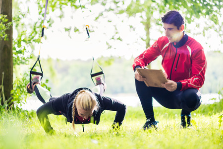 Man and woman at fitness training doing push-upsの写真素材