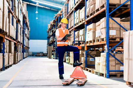 Asian man in industrial warehouse checking list Asian man in industrial warehouse checking list