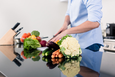 Man cooking and preparing salad in kitchenの写真素材