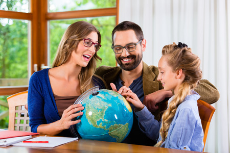 Parents helping daughter with homework assignmentの写真素材