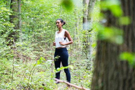 African young woman hiking on forest trackの写真素材