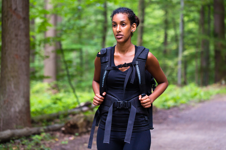 African young woman hiking on forest trackの写真素材