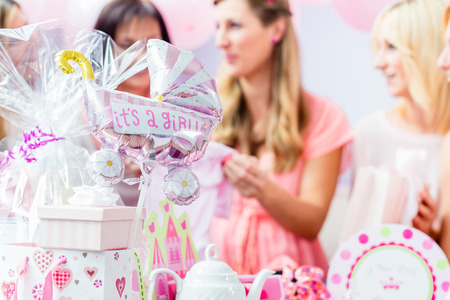 Best Friends on baby shower party celebrating giving kid stuff as presentの写真素材
