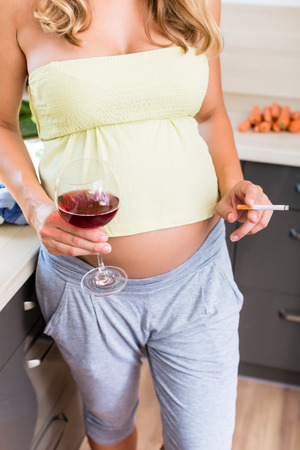 Woman is pregnant but drinks alcohol and smokes cigarettesの写真素材