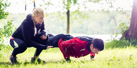 Sport couple outdoors with sling trainer