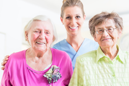 Elderly care nurse with two senior womenの写真素材