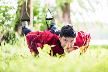 Man doing fitness push-up with sling