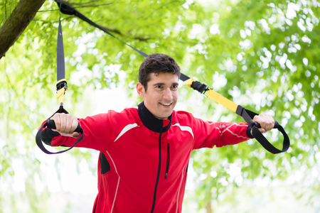 Man doing fitness sling training outdoorsの写真素材