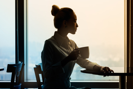 Asian businesswomen in meeting area of office building, looking at tablet computer, filtered imageの写真素材