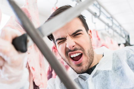 Butcher having fun working in the butcheryの写真素材