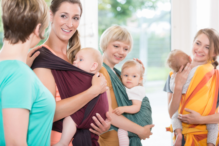 Group of women learning how to use baby slings for mother-child bondingの写真素材