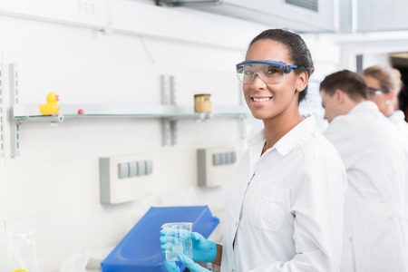 Female lab technician with safety goggles in laboratoryの写真素材