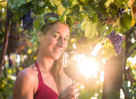 Wine queen visiting her vineyard with sun shining though the vines