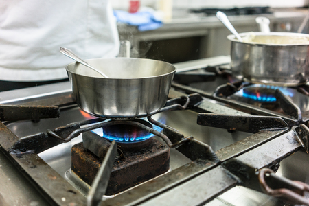 Dish on gas stove in restaurant or hotel kitchenの写真素材