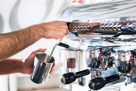 Close-up of the hands of a waiter preparing espresso at an automatic coffee machineの写真素材