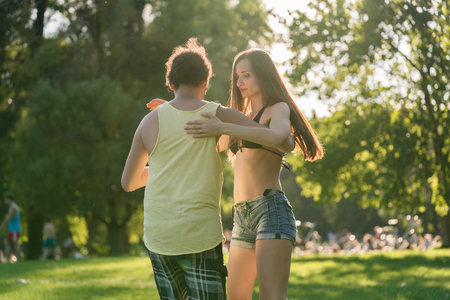 Mann turning woman while dancing Bachata in the sun outdoorsの写真素材