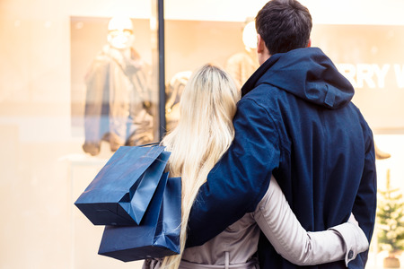 Couple looking at shopping window for Christmasの写真素材