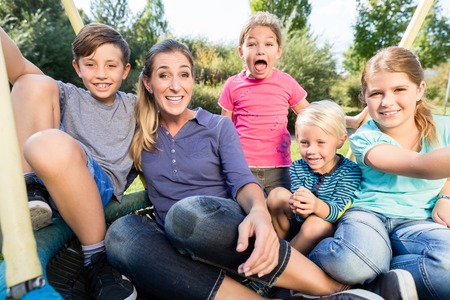 Family with mom, sons and daughters taking photo together outdoorsの写真素材