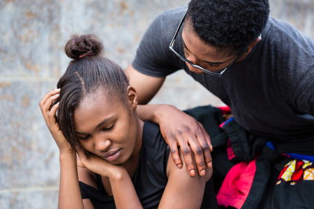 Young man trying to make up with his girlfriend upset after a fight outdoorsの写真素材