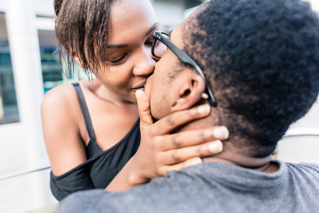 Close-up of African American young couple kissing outdoors in summerの写真素材