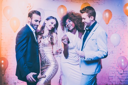 Couples in a club celebrating new years eve dancing into midnight with sparkling wineの写真素材