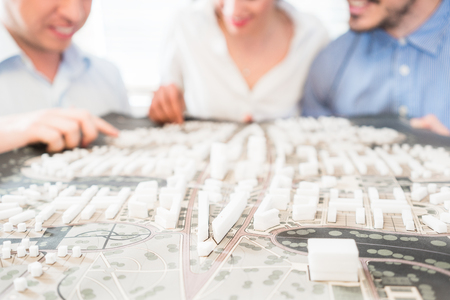 Architects or civil engineers with model for urban development in the office