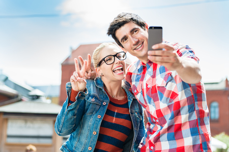 Tourist couple, woman and man, taking holiday selfie on rooftop in Berlinの写真素材