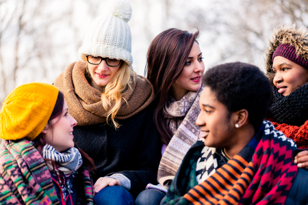 Multi-ethnic group of young people having a good time together outdoors in a cold dayの写真素材
