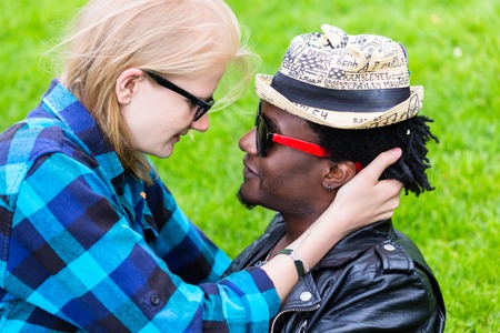 Caucasian woman and African man in loving embrace, looking in each others eyes as a couple