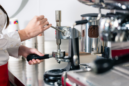 Close-up of the hands of a waiter preparing espresso at an automatic coffee machineの写真素材