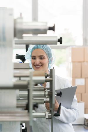 Female manufacturing supervisor looking worried while checking equipment and production during...