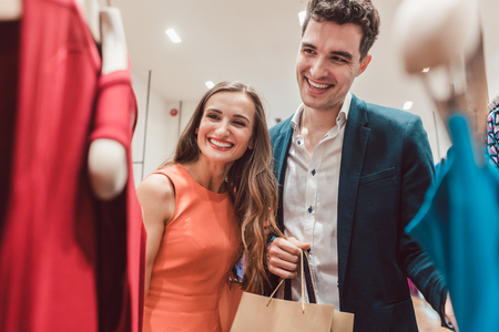 Couple craving for new clothes in fashion shopping spree testing the qualityの写真素材