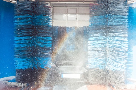Brush turning in car wash with vehicle in itの写真素材