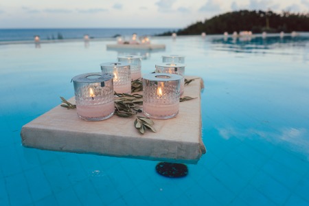 Candles floating in swimming pool at beach house party as decorationの写真素材